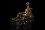 estatua de bronce de mujer desnuda sentada
